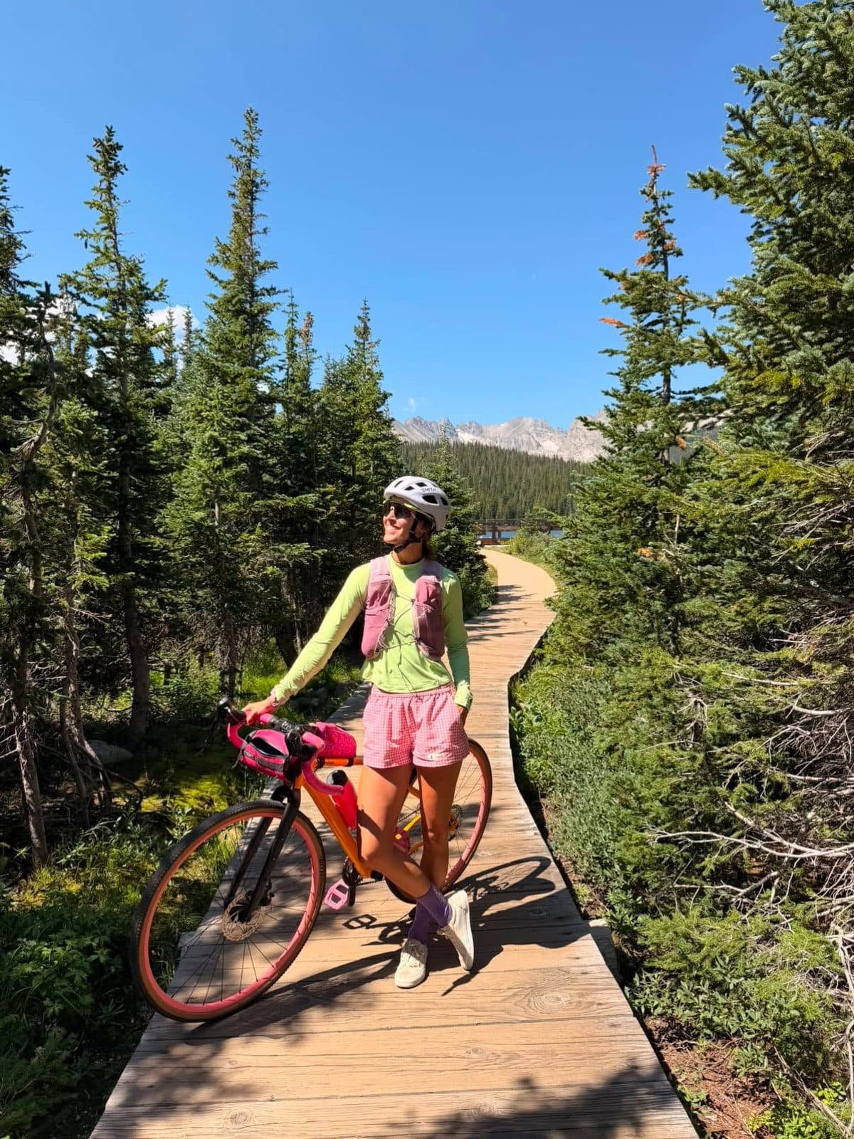 Cyclist in Sierra Shorts on a boardwalk trail through pines