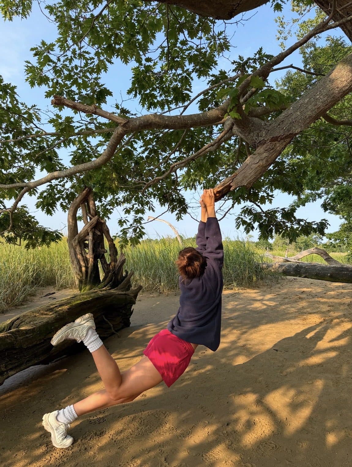 Swinging from a tree branch over a creek in Sierra Shorts